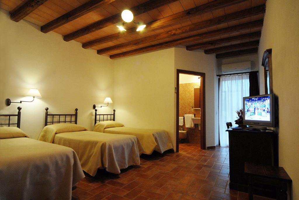 Cette chambre comprend 3 lits et une télévision à écran plat. dans l'établissement Hotel Ristorante da Righetto, à Campagnano di Roma