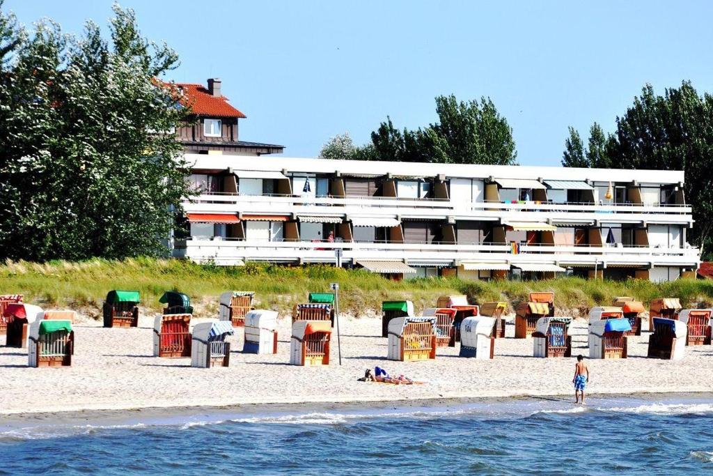 un hôtel sur la plage avec une personne debout dans l'eau dans l'établissement Bellevue-Haus-C-Wohnung-21, à Großenbrode