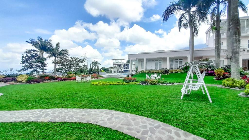 een tuin met een speeltuin en een schommel bij In Villa Garden Resort in Batu