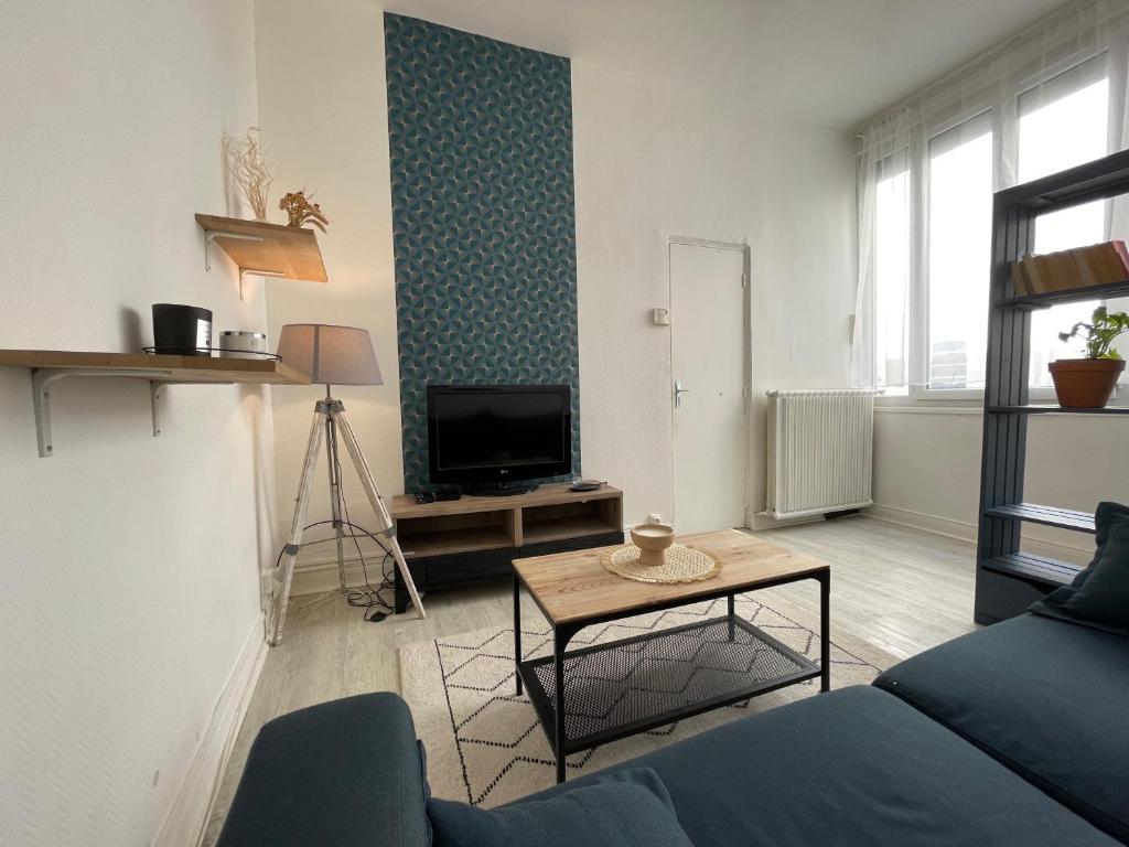 ein Wohnzimmer mit einem Sofa und einem TV in der Unterkunft Appartement à 200 mètres de la gare in Rouen
