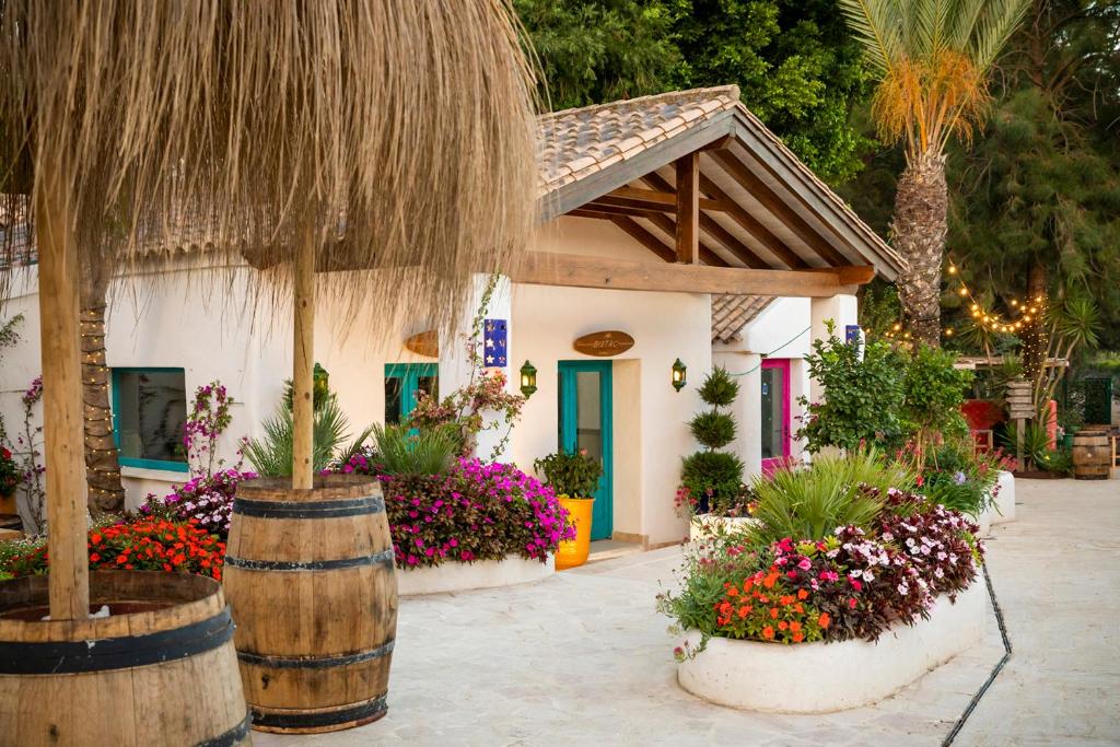 a house with flowers and plants in front of it at Dunas Luxury Beach Resort Tarifa in Tarifa