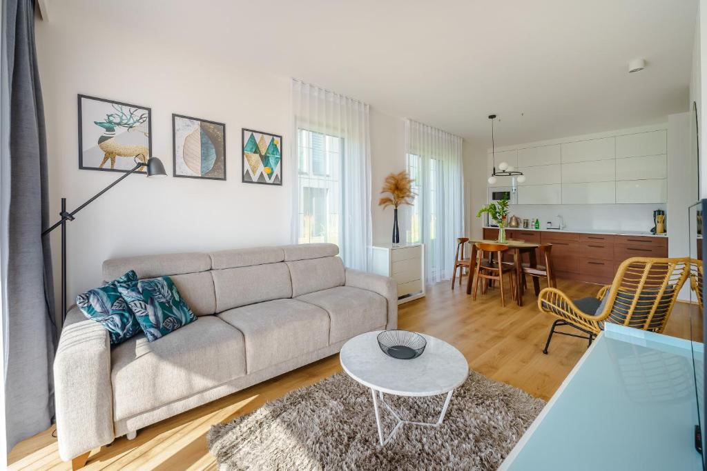a living room with a couch and a table at Apartament WIND SurfingBird Dźwirzyno in Dźwirzyno