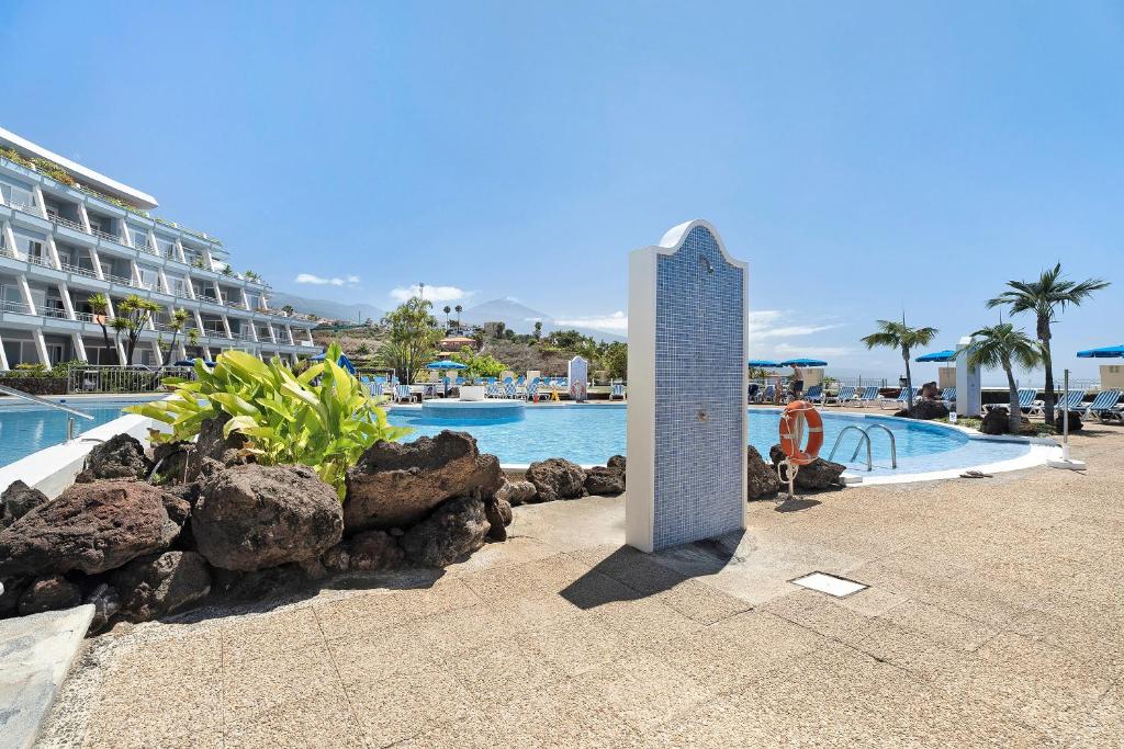 a tall monument in front of a swimming pool at La Quinta in Santa Úrsula