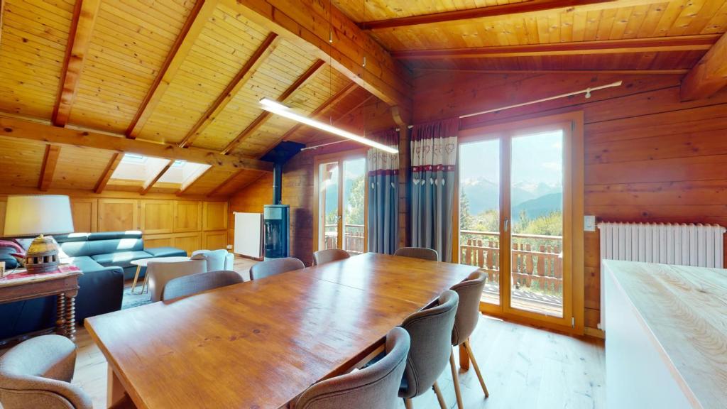 uma sala de conferências com uma mesa de madeira e cadeiras em Apartment with spectacular view of the peaks em Crans-Montana