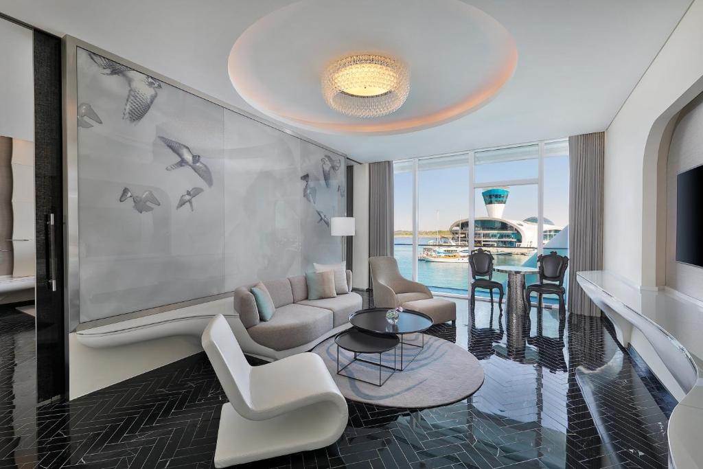 a living room with a couch and chairs and a table at W Abu Dhabi - Yas Island in Abu Dhabi
