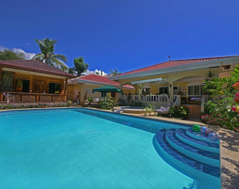a swimming pool in front of a house at Alona Austria Resort in Panglao