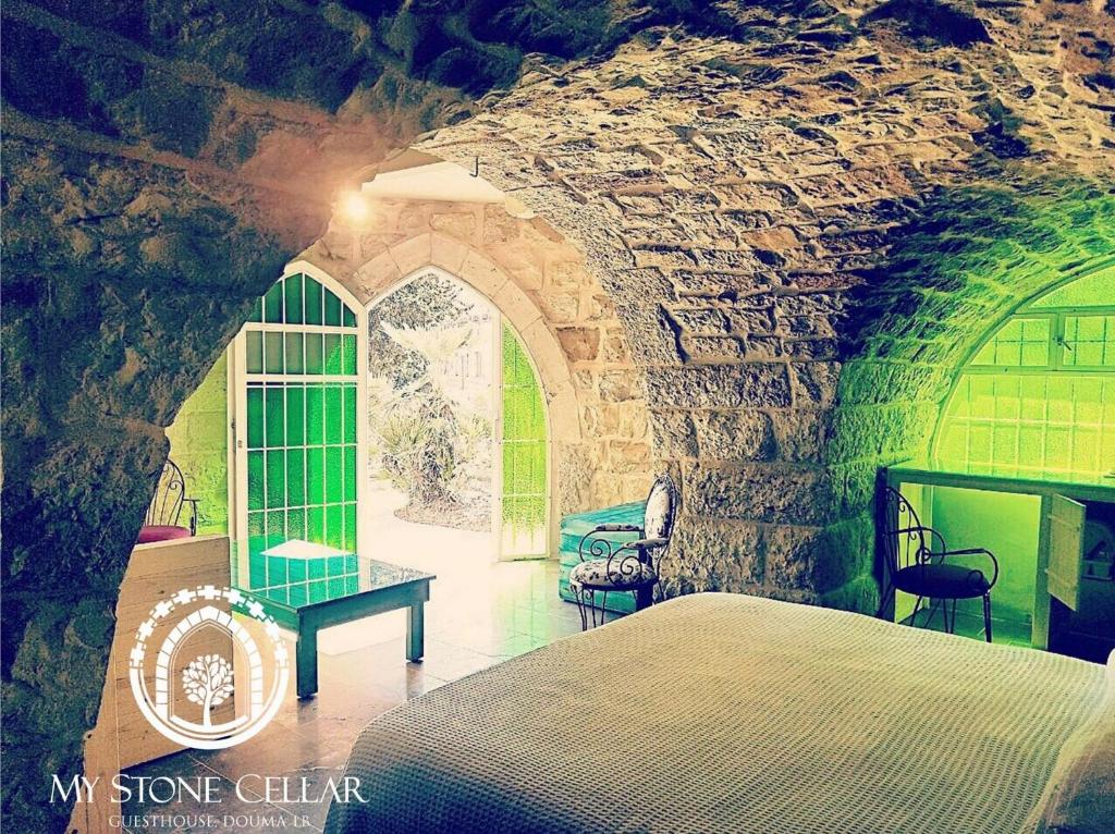 sypialnia z łóżkiem i kamienną ścianą w obiekcie Stone Cellars w mieście Douma