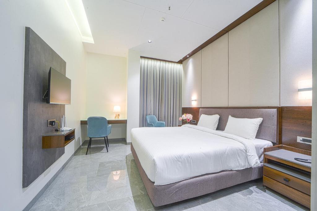 Cette chambre comprend un grand lit et un bureau. dans l'établissement Hotel Devgiri Inn and Restaurant, à Sāngli