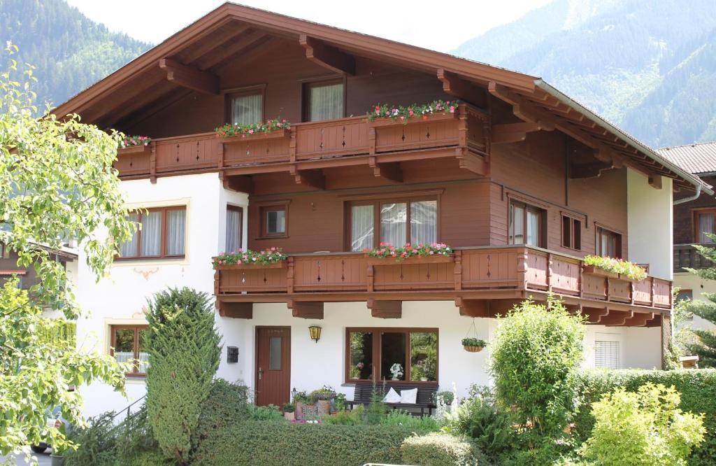 een huis in de bergen met bloemen op de balkons bij Haus Tirolerland in Mayrhofen