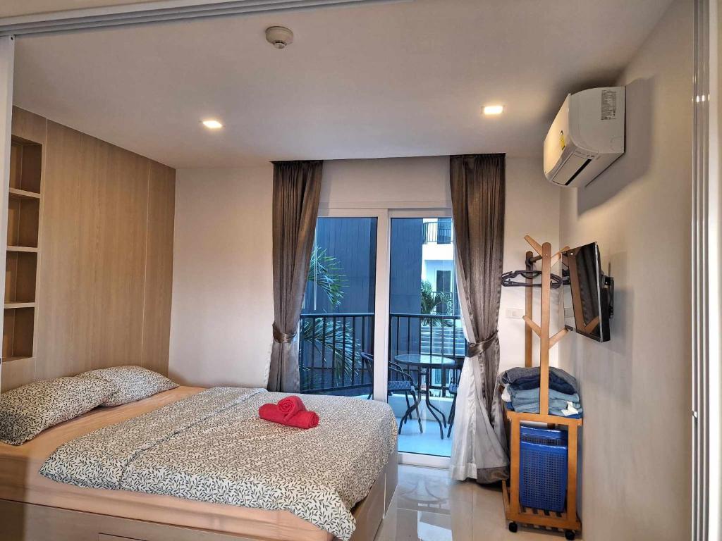 a bedroom with a bed and a view of a balcony at Mantra condominium in Ban Tha Fat