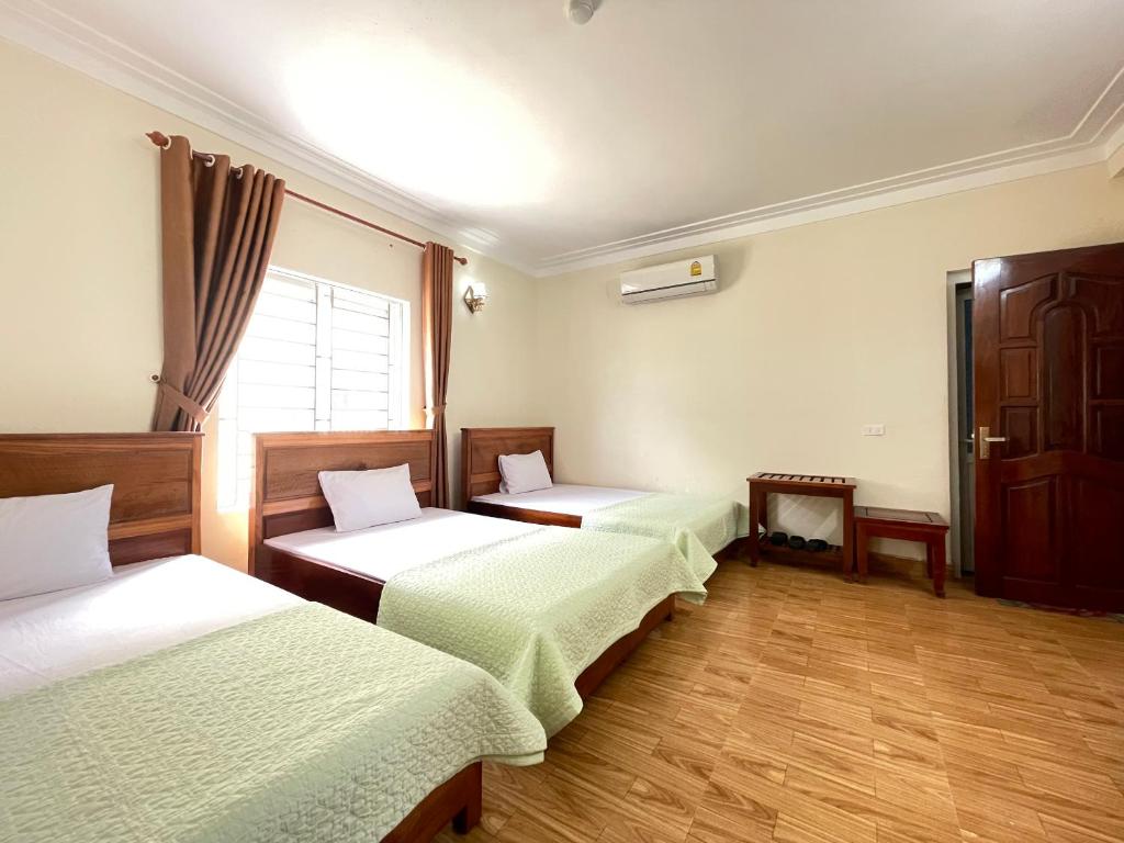 um quarto com três camas e uma janela em Trường Sa Hotel Cửa Lò Beach em Cửa Lò