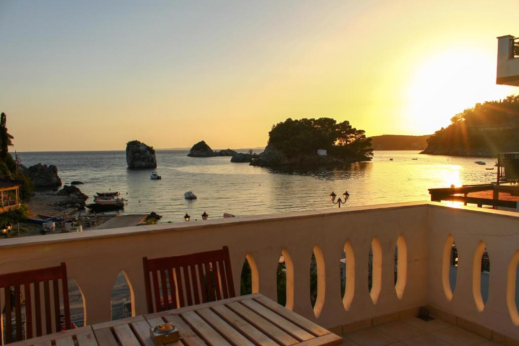 einen Balkon mit Blick auf das Meer und den Sonnenuntergang in der Unterkunft Bakagiannis Apartments in Parga