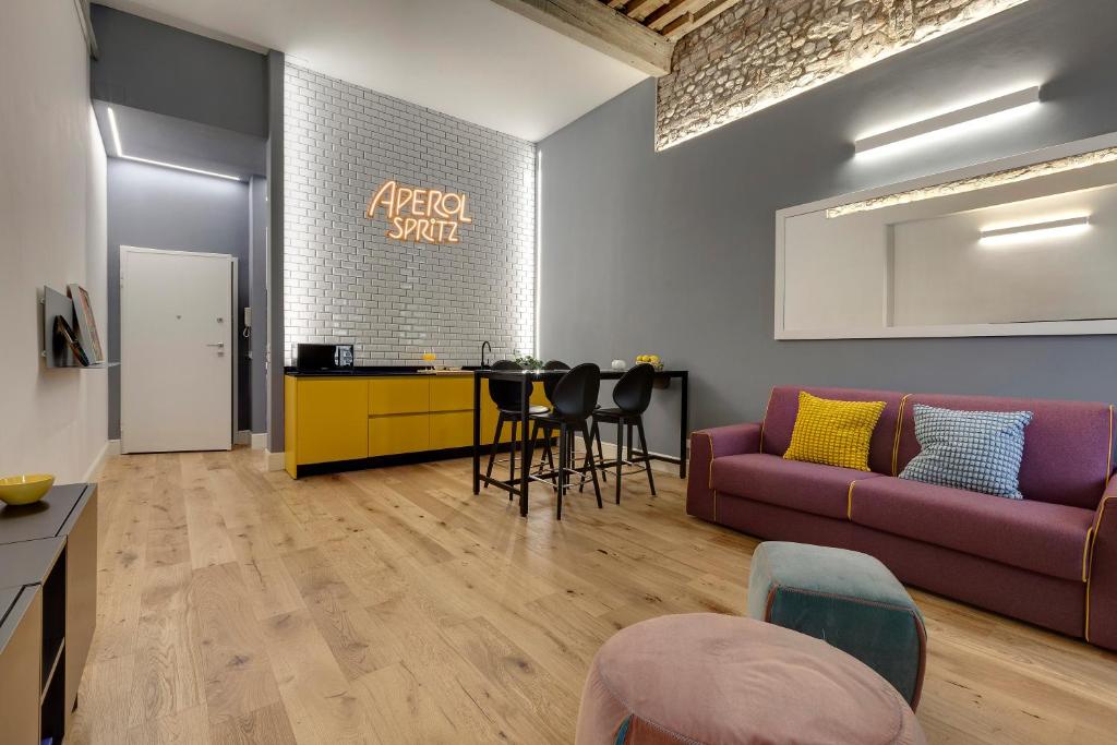 uma sala de estar com um sofá e uma mesa em Mamo Florence - Aperol & Spritz Apartments em Florença