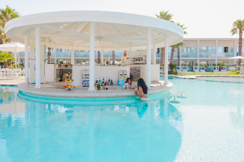 een persoon in een paviljoen in het water van een resort bij Marelive - CDSHotels in Torre dell'Orso