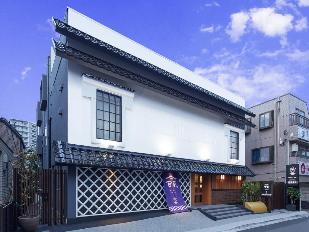une maison blanche avec une façade noire et blanche dans l'établissement Stay SAKURA Tokyo Shinjuku Hyakukura, à Tokyo