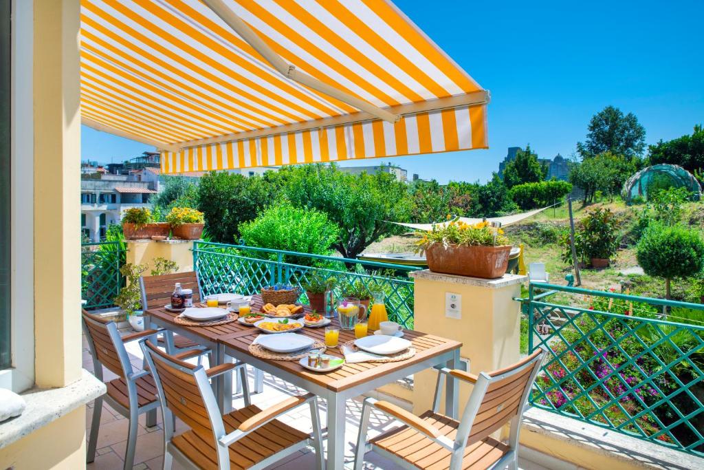d'une table et de chaises sur un balcon avec un parasol dans l'établissement B&B Marcantonio - Ischia Ponte, à Ischia