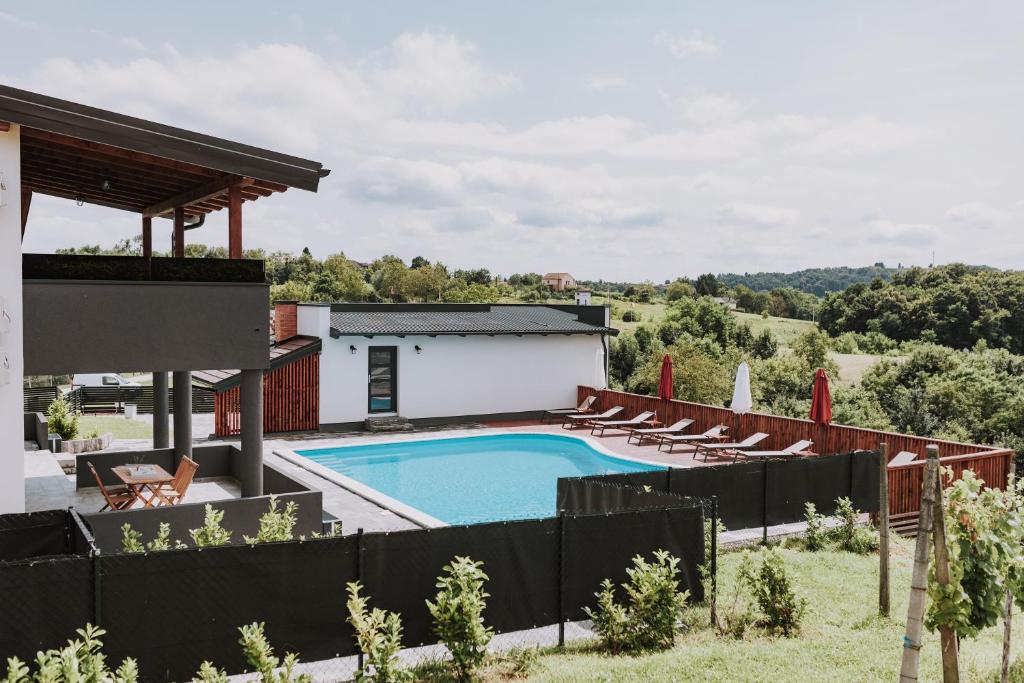 a villa with a swimming pool and lounge chairs at MY HOME ADDL in Štrigova