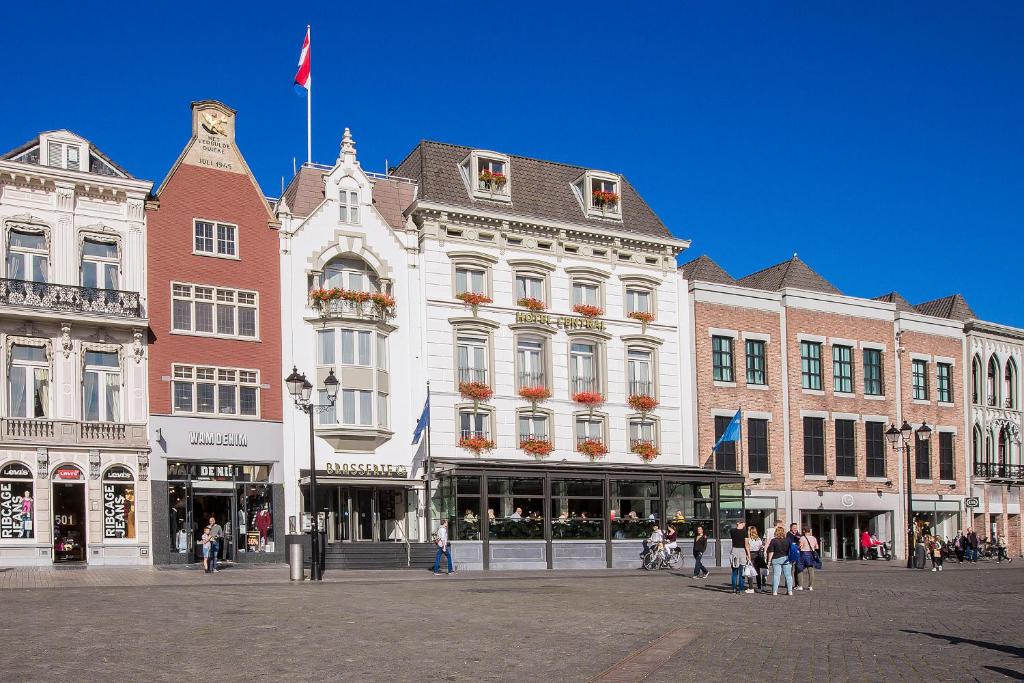 un gran edificio con una bandera encima en Golden Tulip Hotel Central en Den Bosch