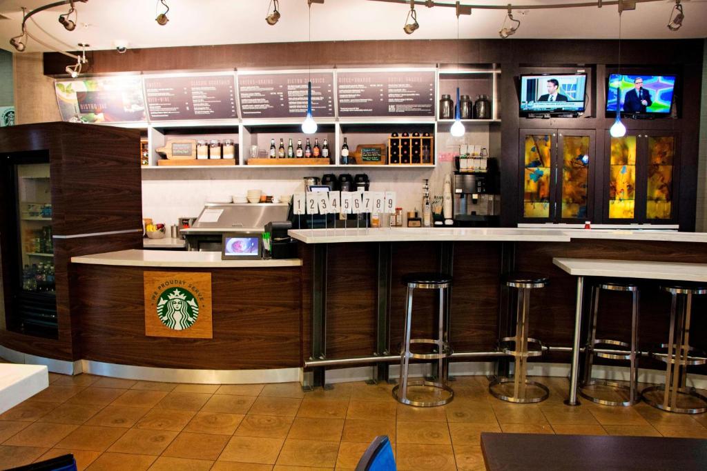 a bar in a restaurant with bar stools at Courtyard by Marriott Battle Creek in Battle Creek