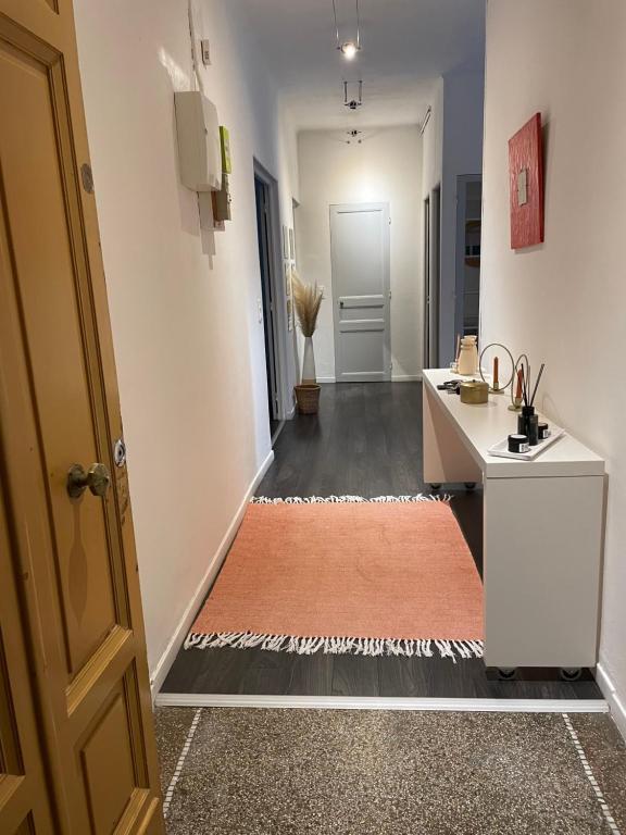 a hallway with an orange rug on the floor and a door at Spacieux T3 haussmannien in Toulon