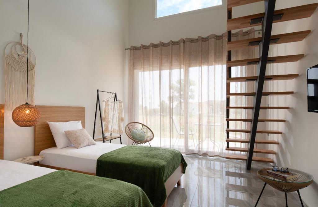 a bedroom with two beds and a large window at Campania Loft Apartments in Sikia