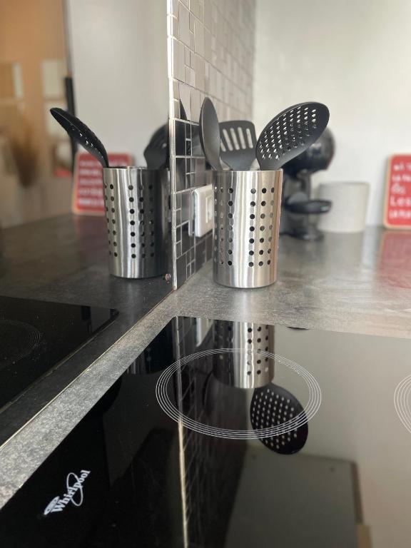 three metal utensils are on a counter in a kitchen at Spacieux T3 haussmannien in Toulon