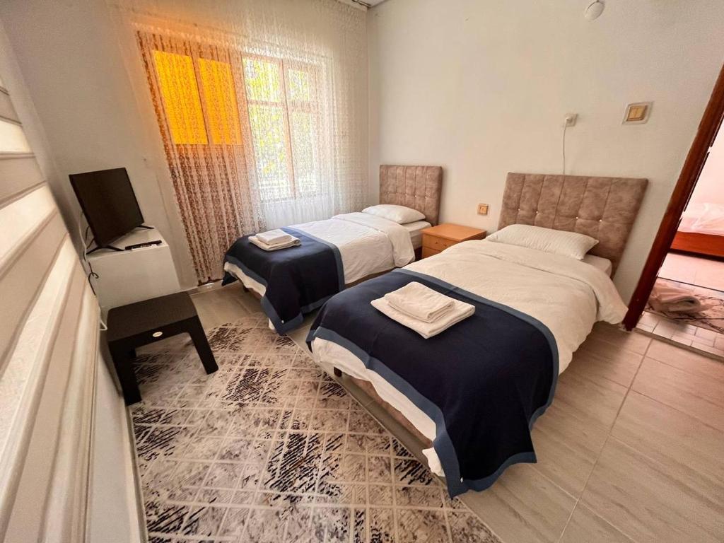 a hotel room with two beds and a television at DALAMAN 2 ODALI DAİRE in Dalaman