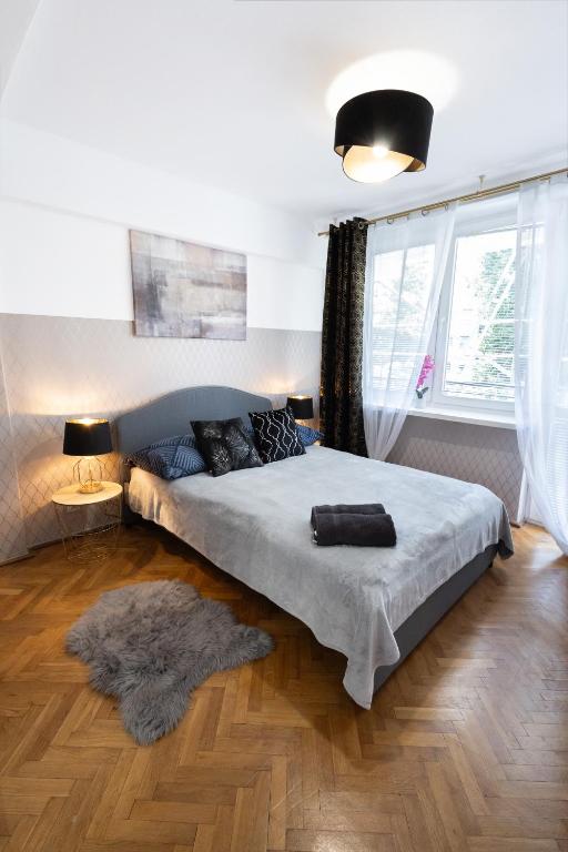 sypialnia z łóżkiem i dużym oknem w obiekcie ClickTheFlat Muranów Apart Rooms w Warszawie