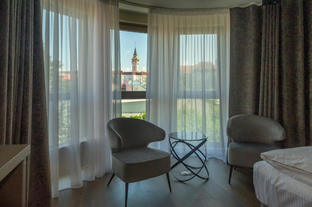 a hotel room with two chairs and a window at Atlantic Boutique in Târgu-Mureş