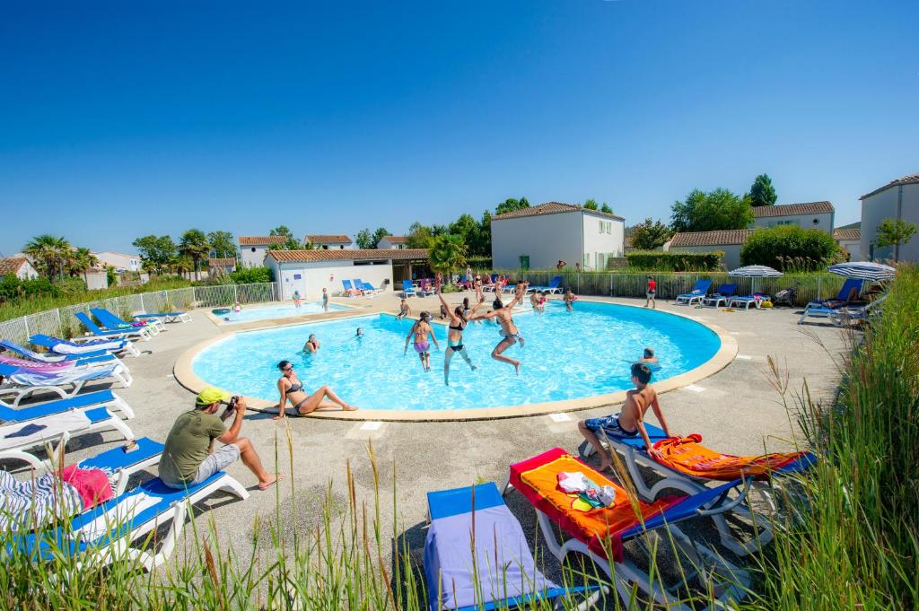 un groupe de personnes dans une piscine dans l'établissement Résidence Goélia La Palmeraie, à Saint-Georges-dʼOléron