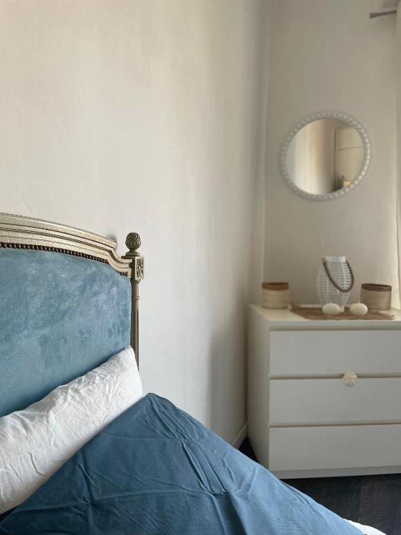 a bedroom with a bed and a dresser with a mirror at Spacieux T3 haussmannien in Toulon