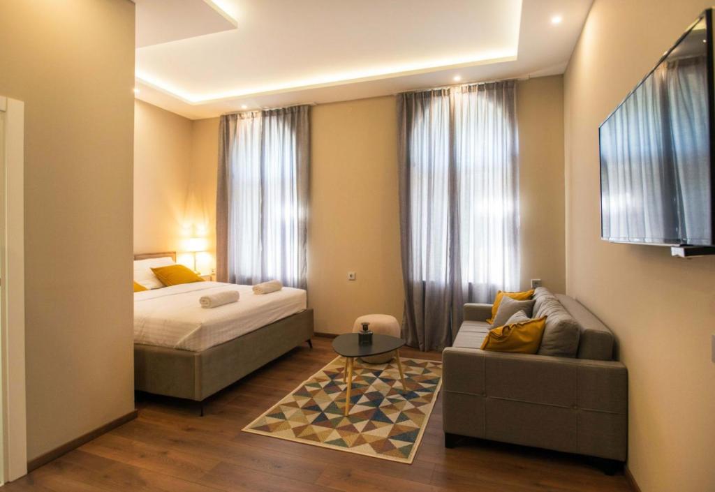 ein Hotelzimmer mit einem Bett und einem Sofa in der Unterkunft Hotel Nacional in Bosanska Gradiška