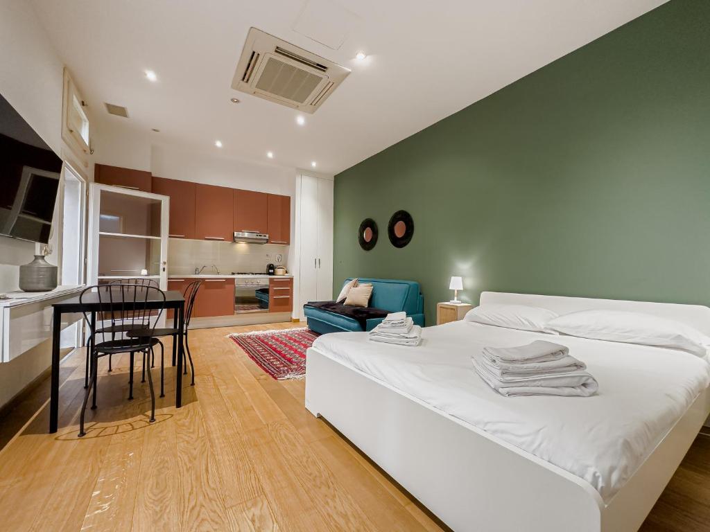 ein Schlafzimmer mit einem Bett und einem Tisch sowie eine Küche in der Unterkunft Realkasa Belfiore Apartment in Bologna