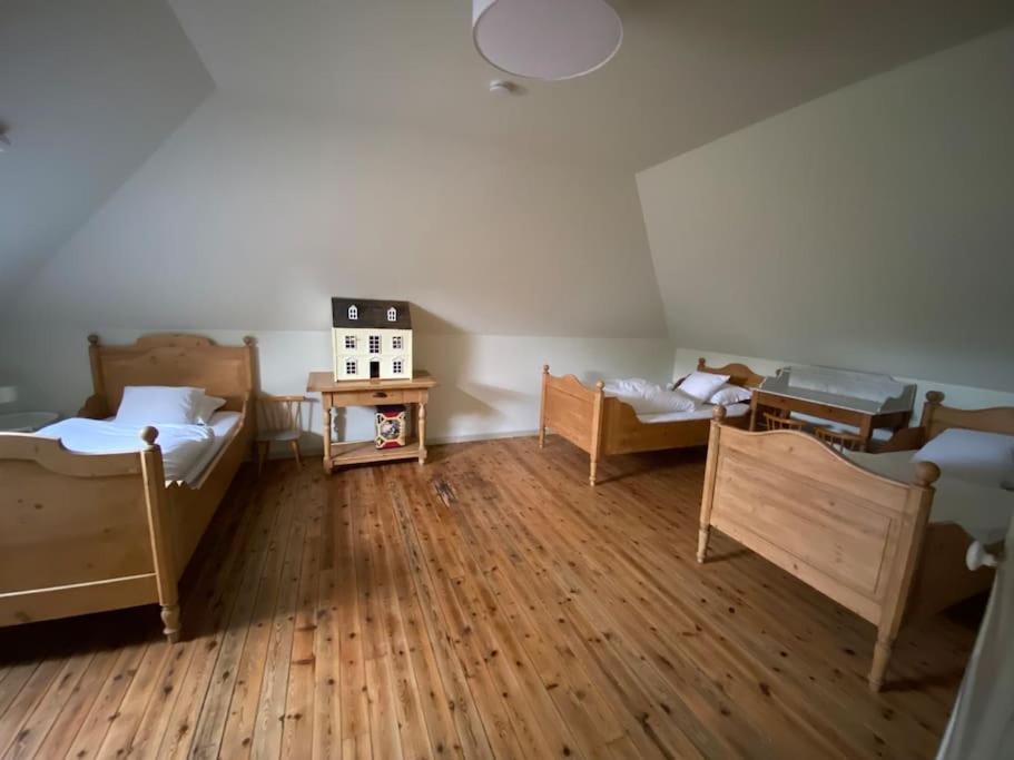 Zimmer mit 3 Betten und Holzboden in der Unterkunft Le presbytère in Cayeux-sur-Mer