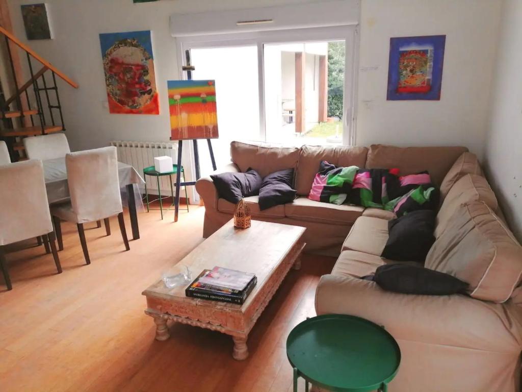 un salon avec un canapé et une table dans l'établissement le coin du bois en Touraine, à Château-la-Vallière