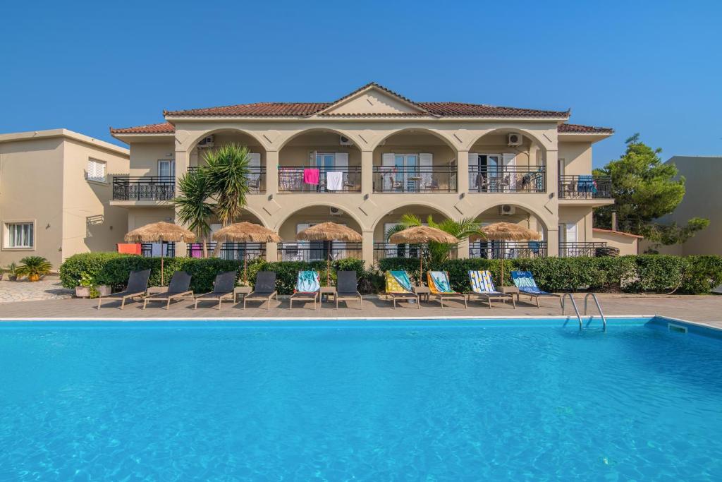 a resort with a swimming pool in front of a building at Grapevines Hotel in Alikanas