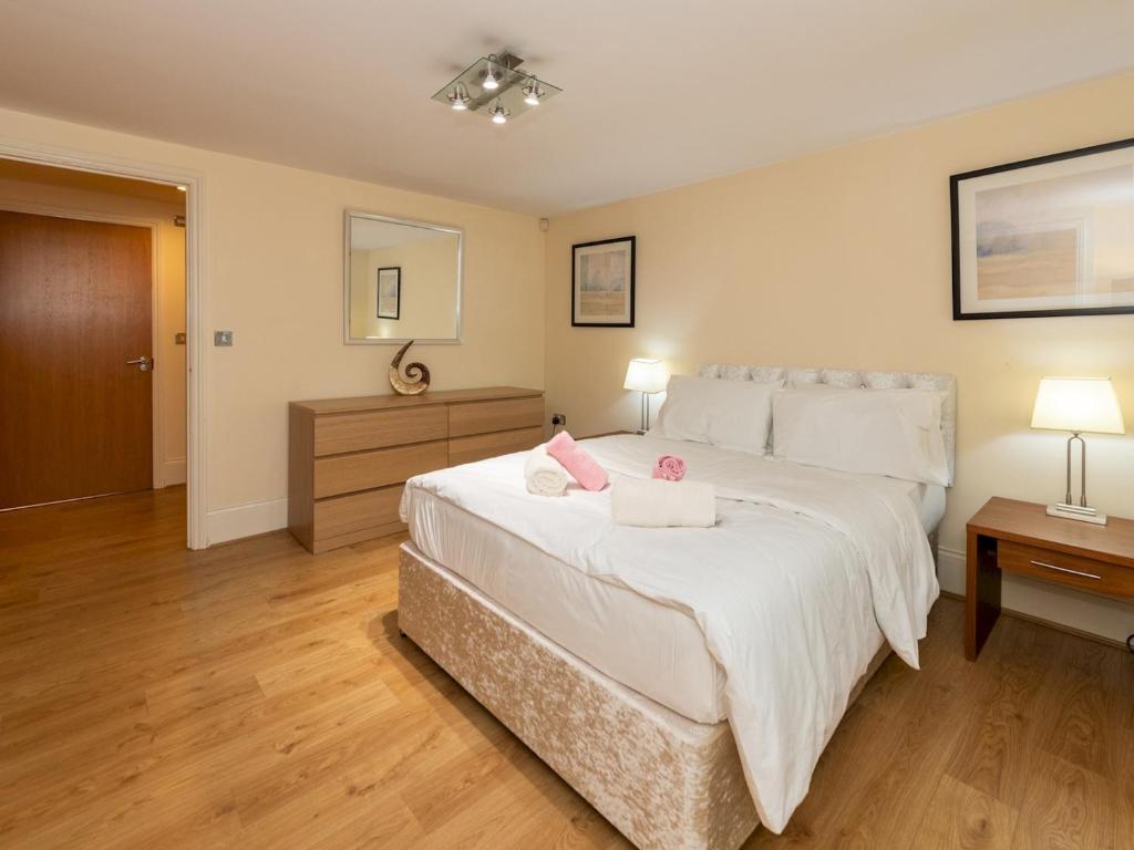 a bedroom with a large bed with two towels on it at Pass the Keys Charming 3 BDR Home close to Reading Town Centre in Reading