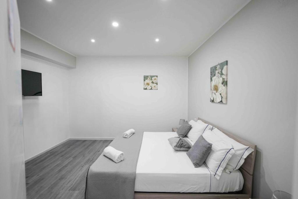um quarto branco com uma cama e uma televisão em Capodichino Apartment 127 - 20 em Nápoles