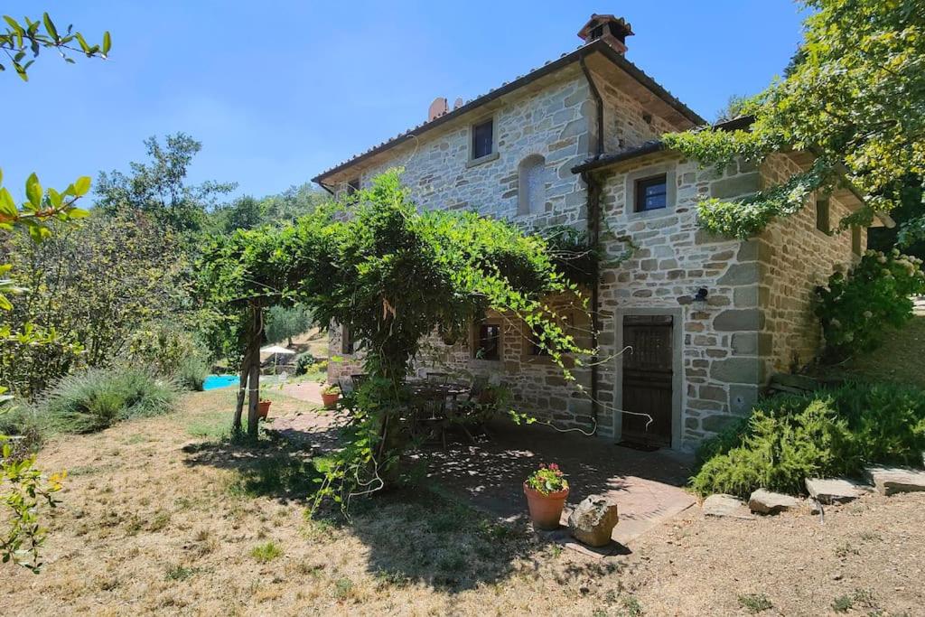 une vieille maison en pierre avec un jardin devant dans l'établissement CASA CAROLE - Lake View Villa, à Caprese Michelangelo
