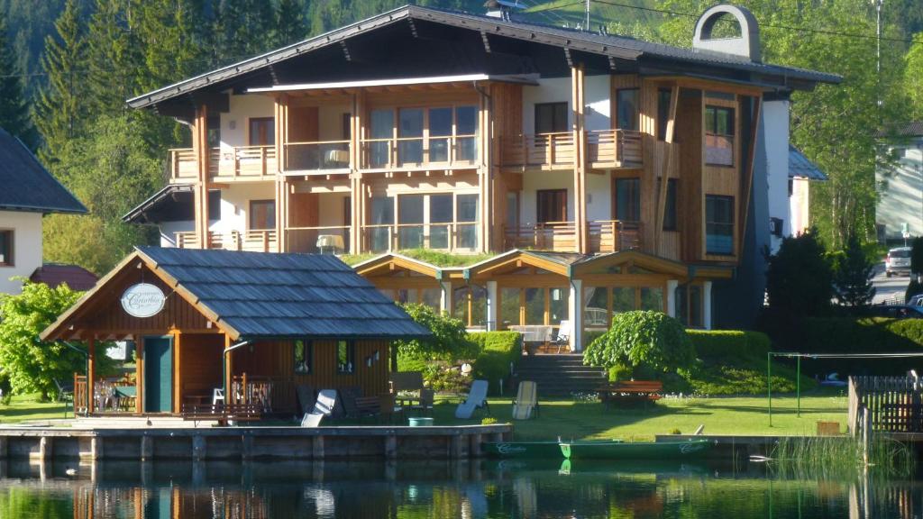 ein großes Haus am Wasser mit einem Dock in der Unterkunft Carinthia in Weissensee