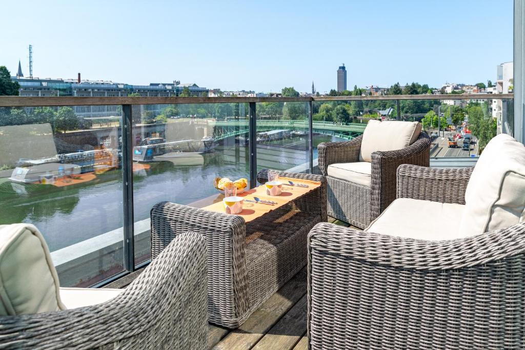 balcone con sedie e tavolo con vista sul fiume di Au Fil de L'Erdre - Spacieux appt avec terrasse a Nantes