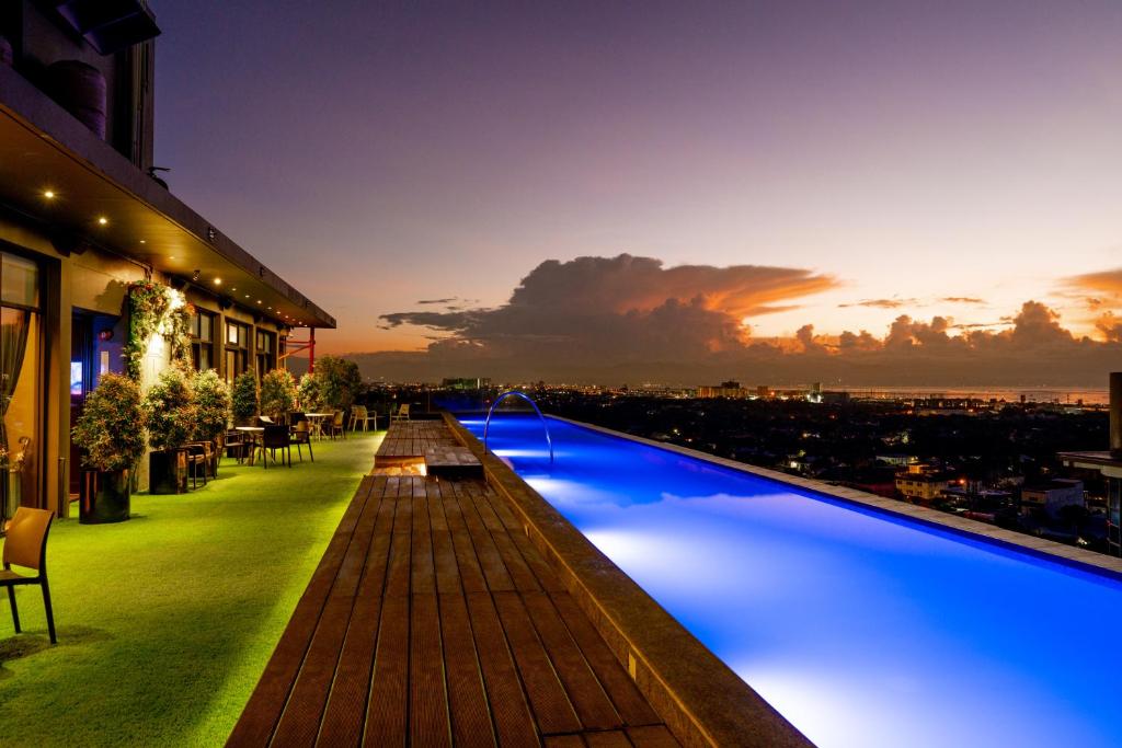 a hotel swimming pool with a view of a city at Azumi Boutique Hotel in Manila