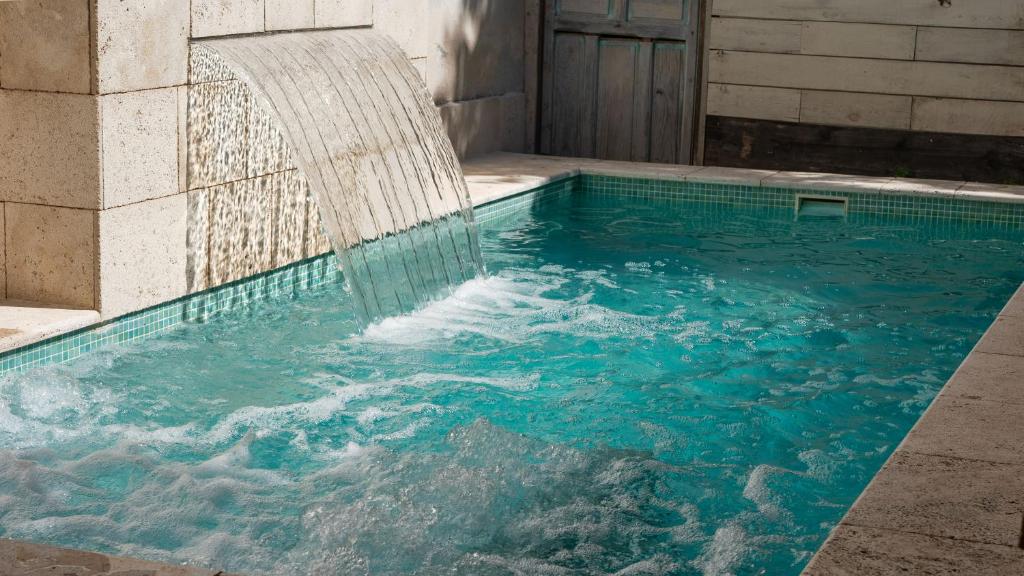a swimming pool with a water fountain at Casa Rural La Chocolateria in Horche