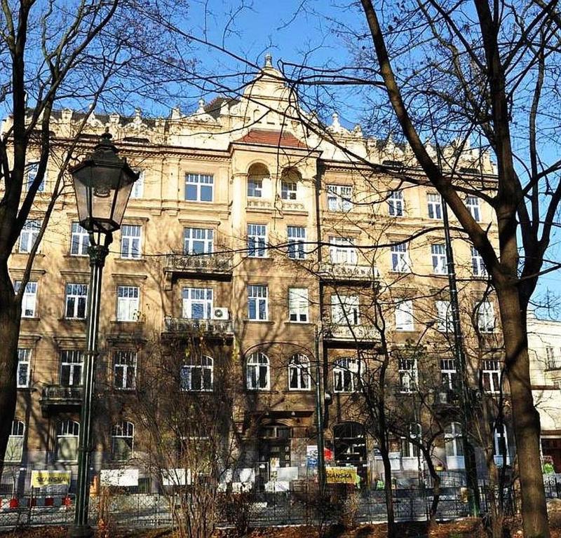 een groot gebouw met een straatlicht voor het bij Green Cat Rooms in Krakau