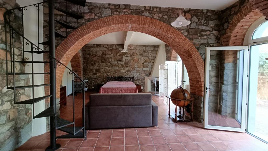 uma arcada num quarto com um sofá e uma cama em La Casa di Zia Zaira em Bari Sardo