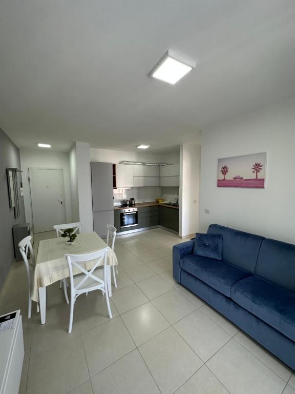 - un salon avec un canapé bleu et une table dans l'établissement Merville Apartment 6, à Durrës