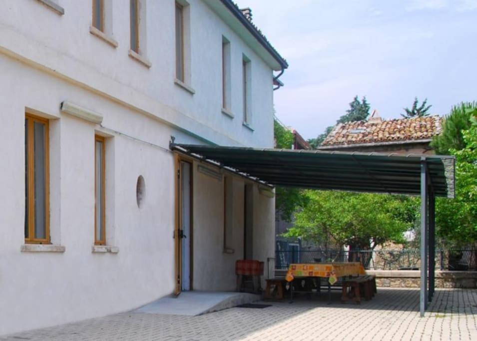 een patio met een zwarte luifel naast een wit gebouw bij Ostello della gioventù Intera struttura in Lama dei Peligni