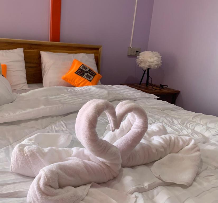 a pair of swans made out of towels on a bed at Heaven Guesthouse in Pakse