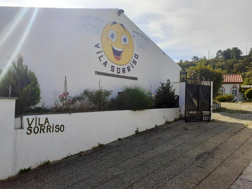 a white building with a smiley face sign on it at Studio with shared pool enclosed garden and wifi at Monchique in Monchique