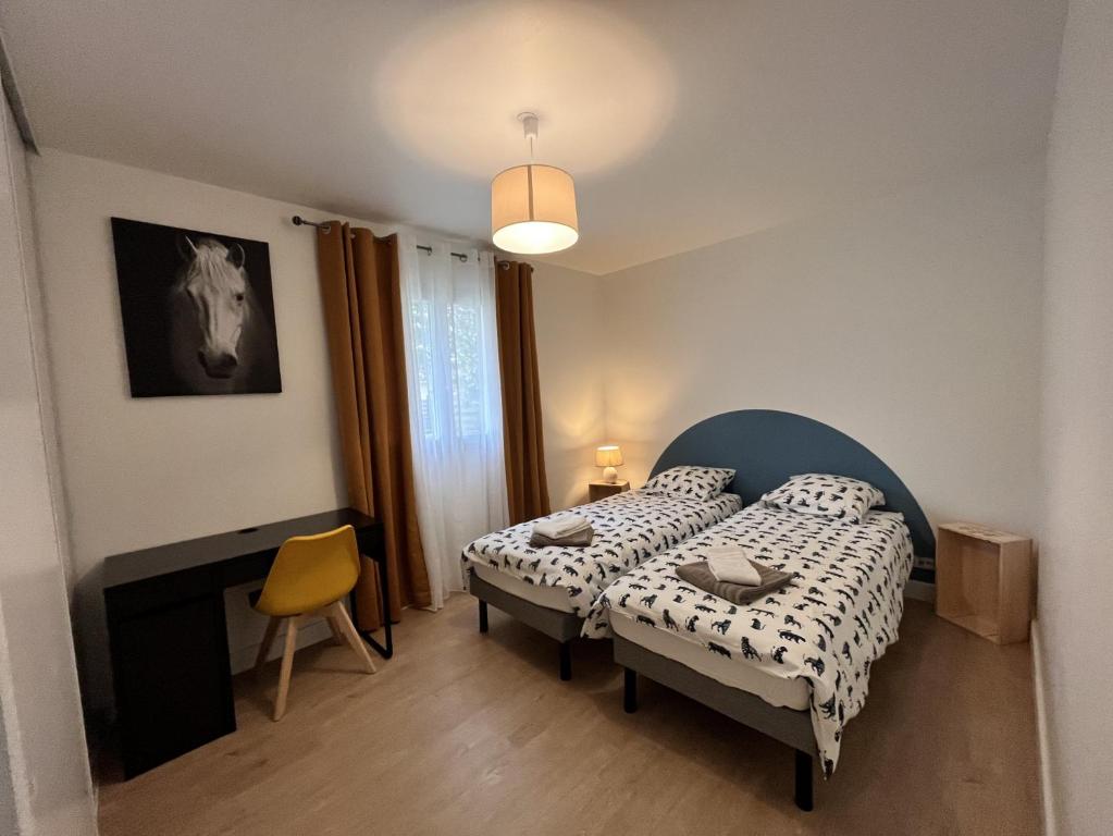 une petite chambre avec deux lits et une cheminée dans l'établissement VillasHomeClet - Villa Côte & Lac, à Naujac-sur-Mer
